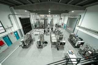 Bioprocess validation room with stainless vessels, filtration equipment and control systems.