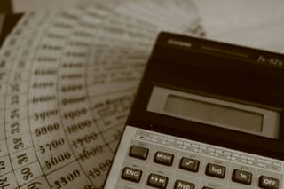 A calculator rests on accounting ledger sheets.